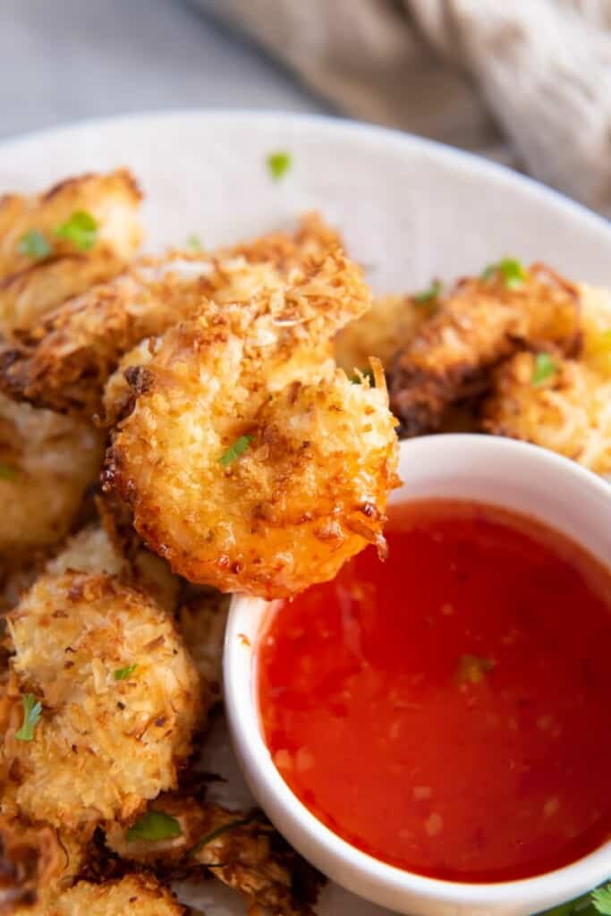coconut shrimp on a platter with dipping sauce