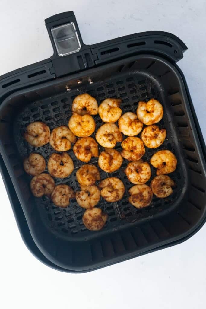 cooked shrimp in an air fryer basket