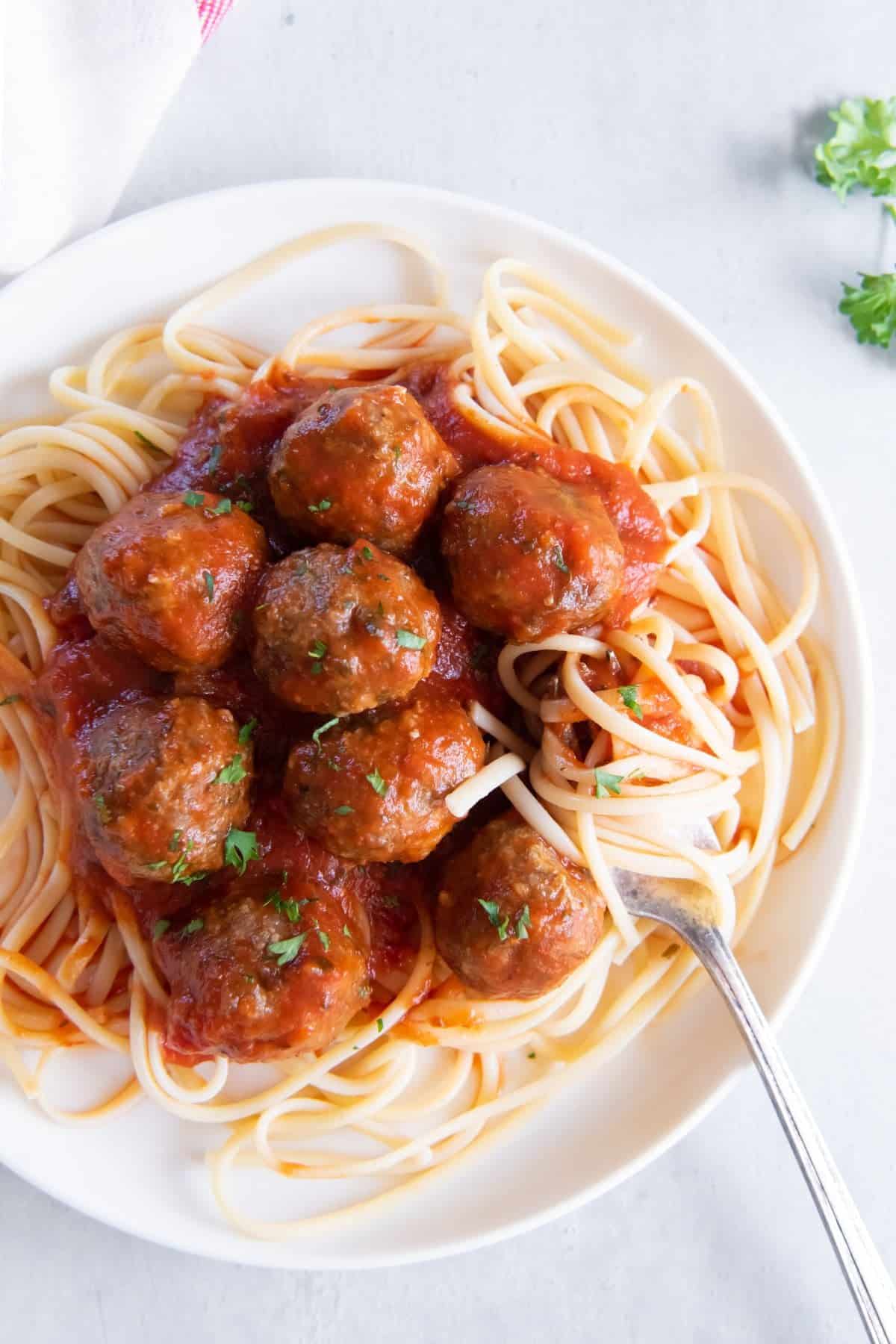 Air fryer turkey meatballs covered in tomato sauce and served over spaghetti.