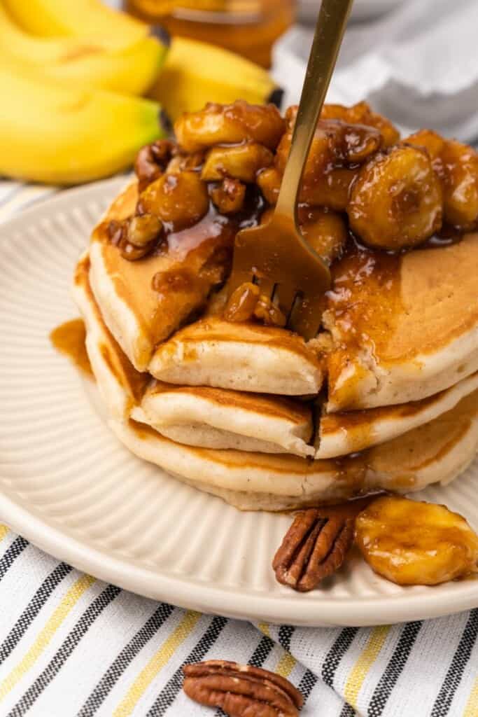 fork cutting banana foster pancakes