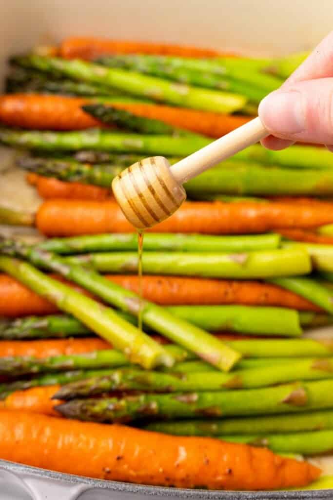 drizzling honey on carrots and asparagus