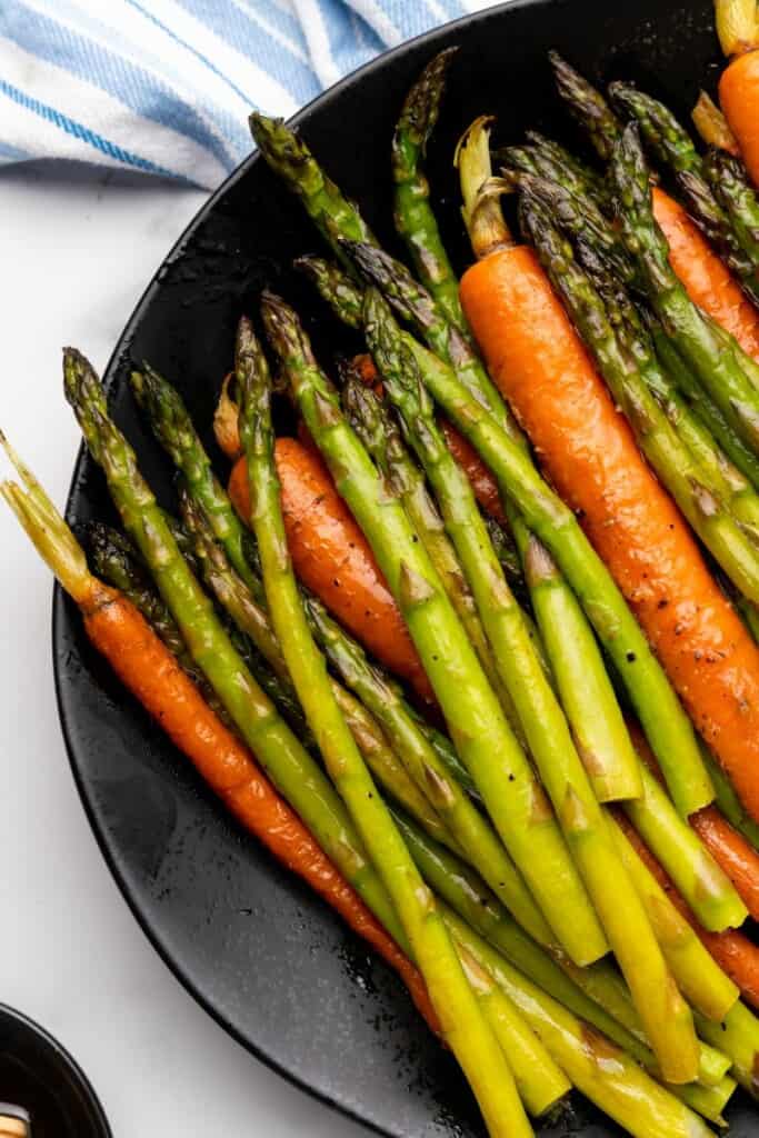 roasted carrots and asparagus on a black plate