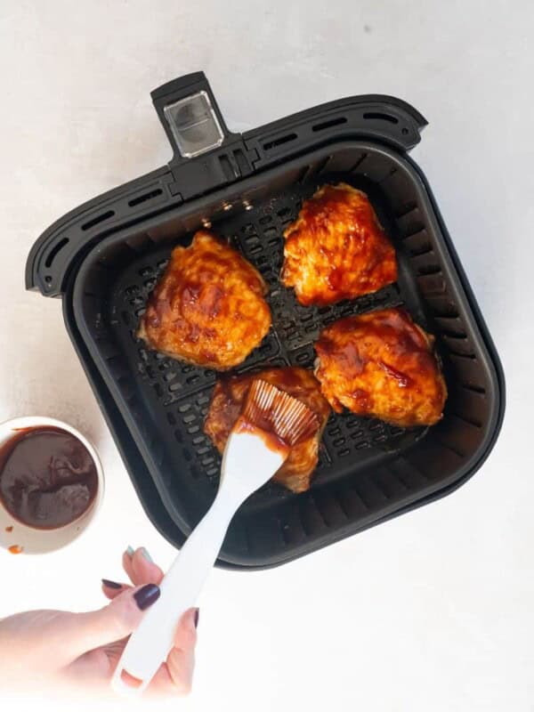 adding sauce to chicken thighs