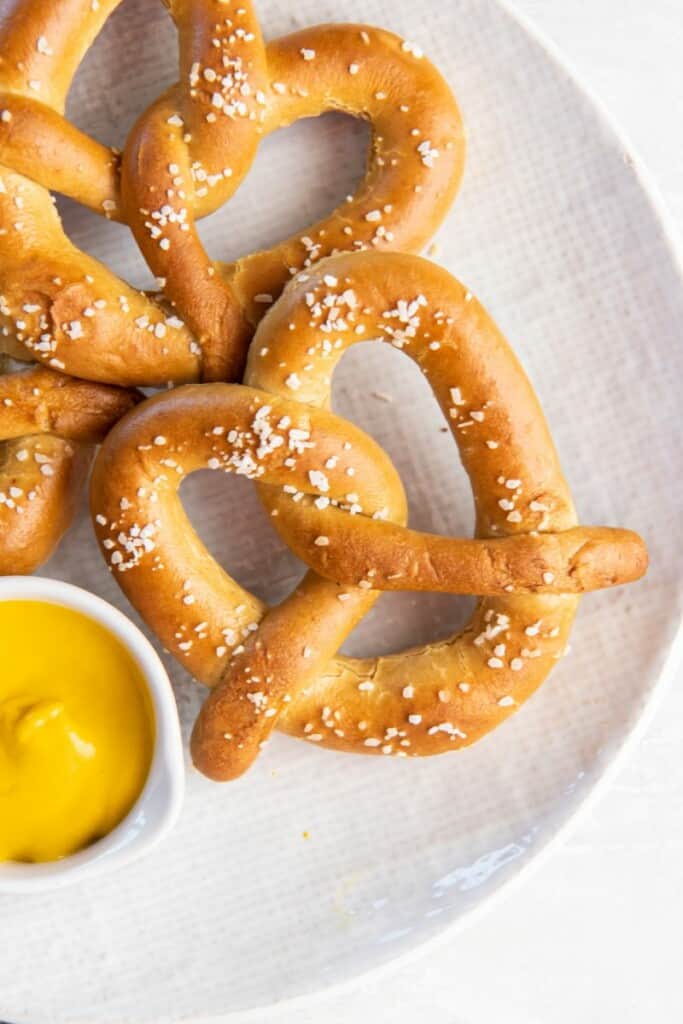 soft pretzels on a platter with dipping sauce