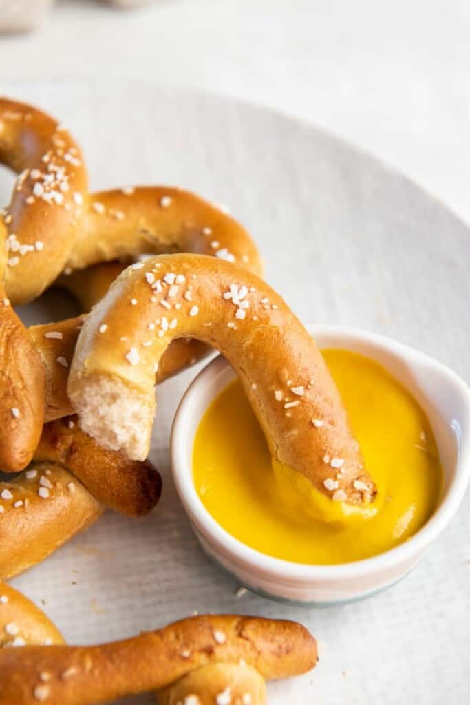 pretzel being dunked in sauce