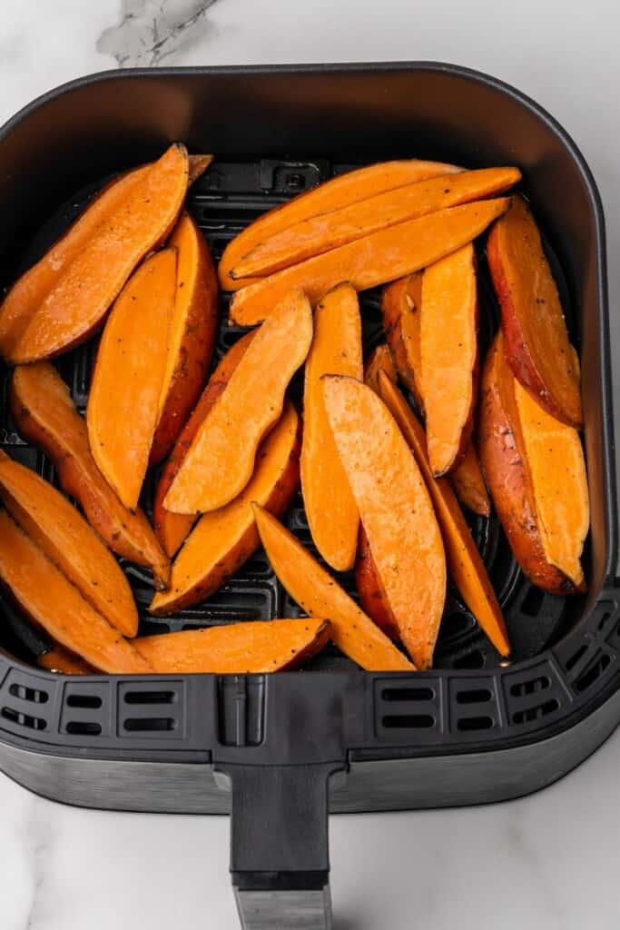 raw sweet potatoes in air fryer basket