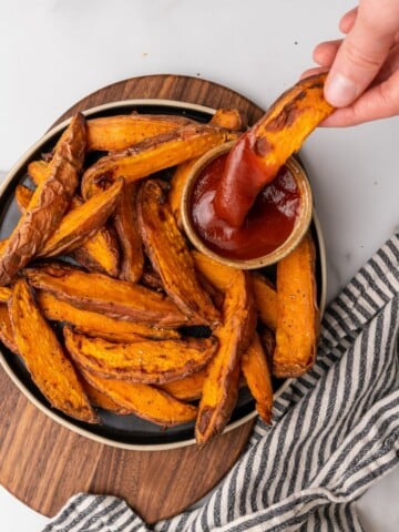 dipping sweet potato wedge into ketchup