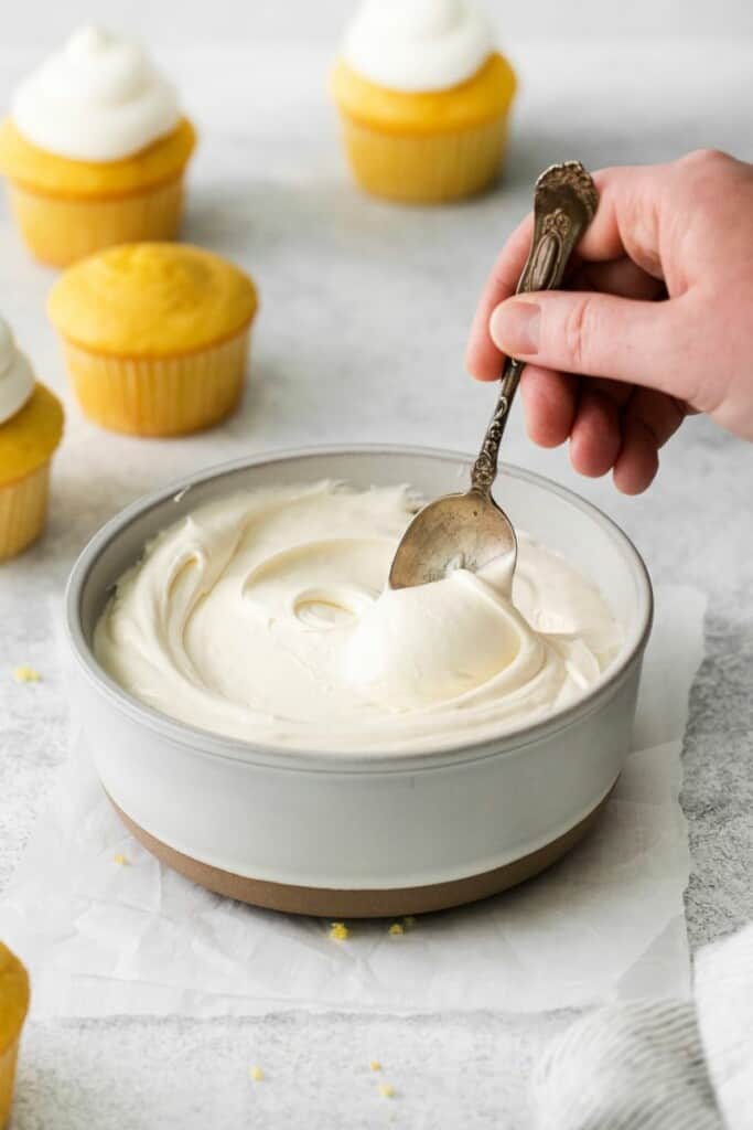 spoon stirring into cool whip creamcheese frosting