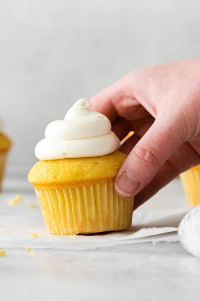 hand holding frosted cupcake