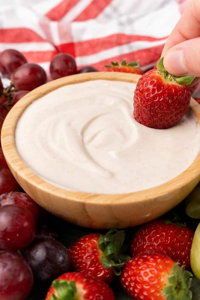 dipping strawberry into fruit dip