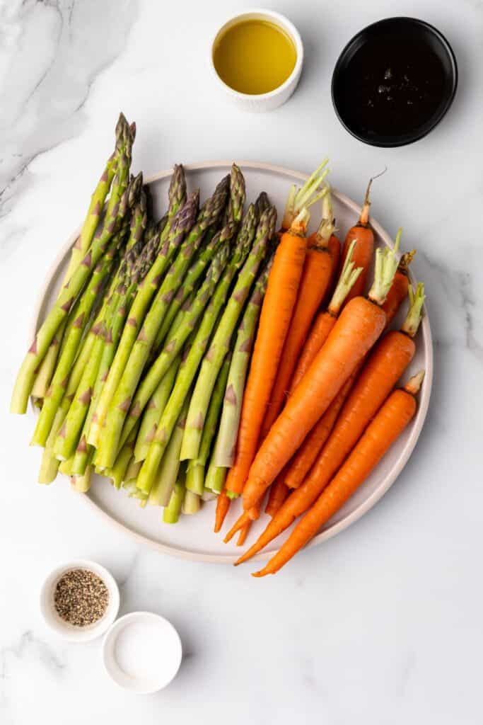 Ingredients needed to make roasted carrots and asparagus: carrots, asparagus, olive oil, salt, pepper, and honey.