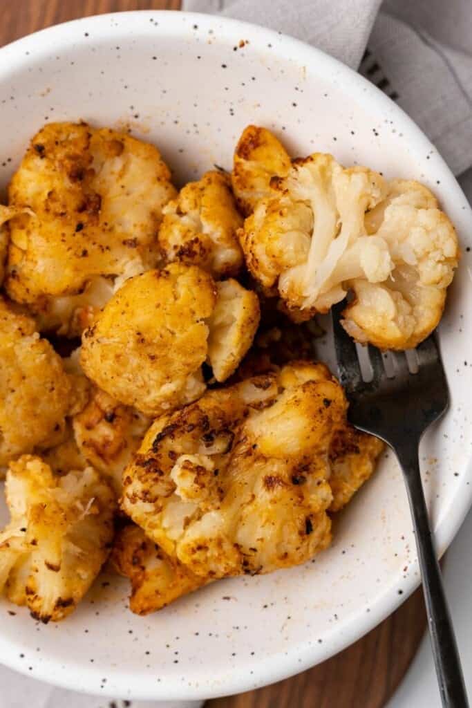 air fried cauliflower in a bowl with a fork