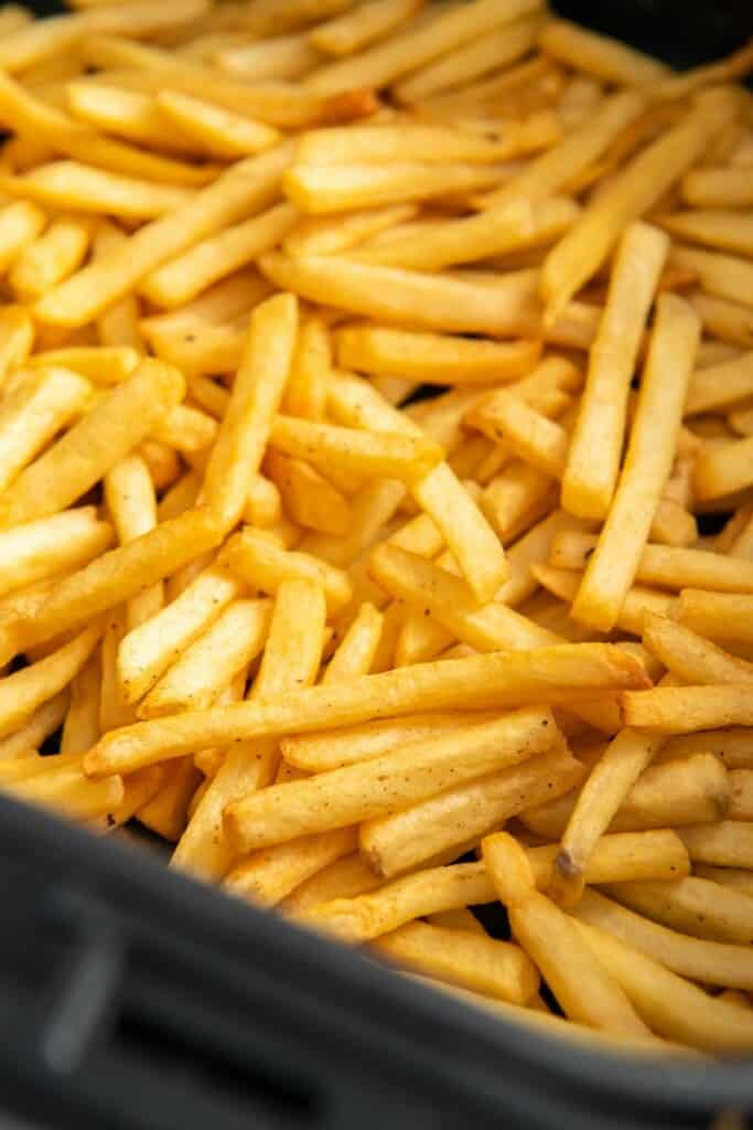 closeup of golden brown french fries in air fryer basket