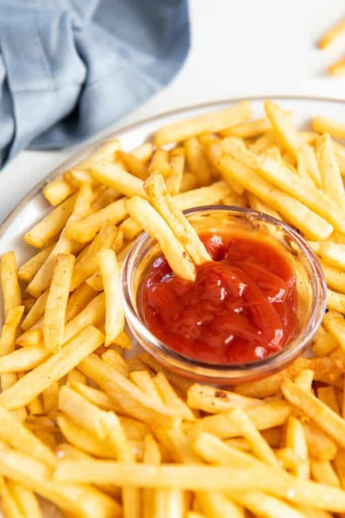 dipping fries into ketchup