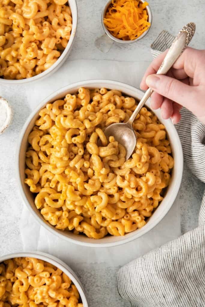 spoon digging into bowl of mac and cheese