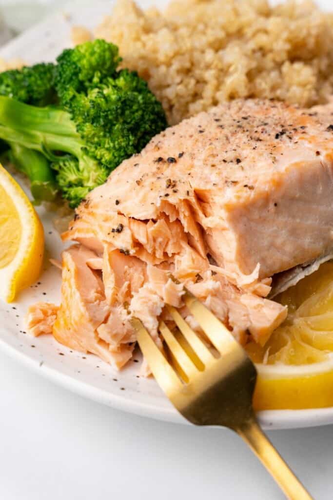 fork cutting salmon