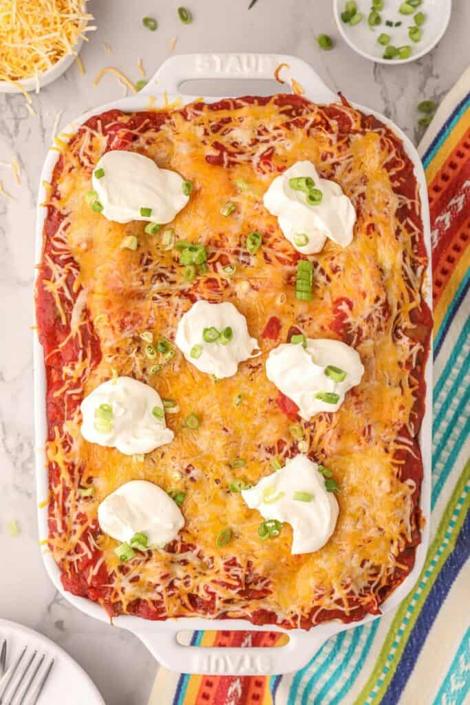 overhead view of the taco lasagna with sour cream dollops and green onions on top