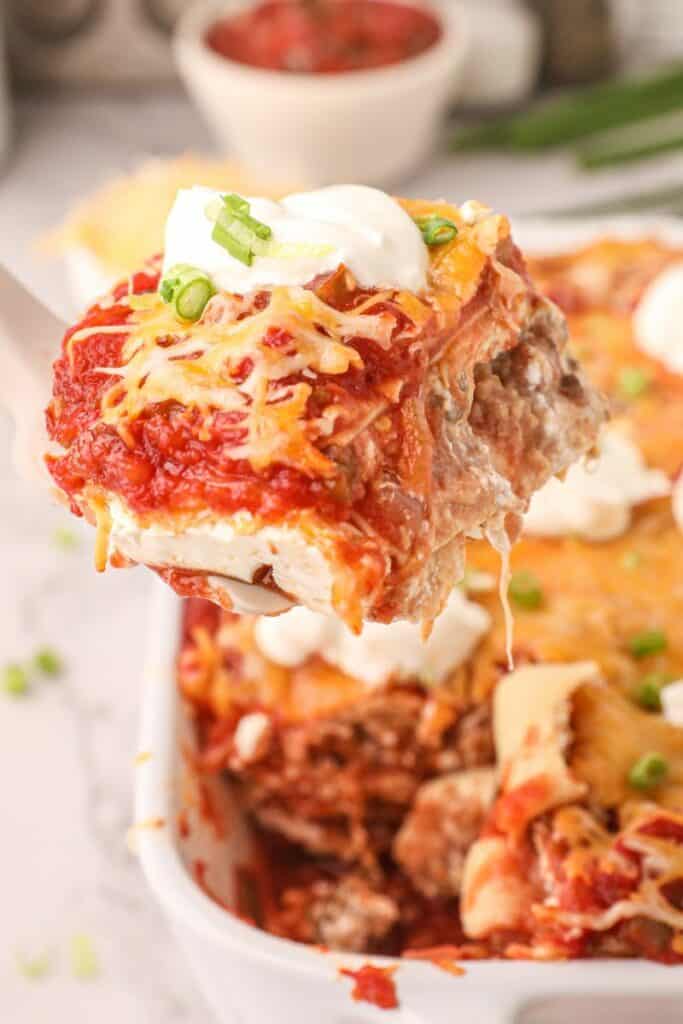 taco lasagna slice being pulled out of the casserole dish