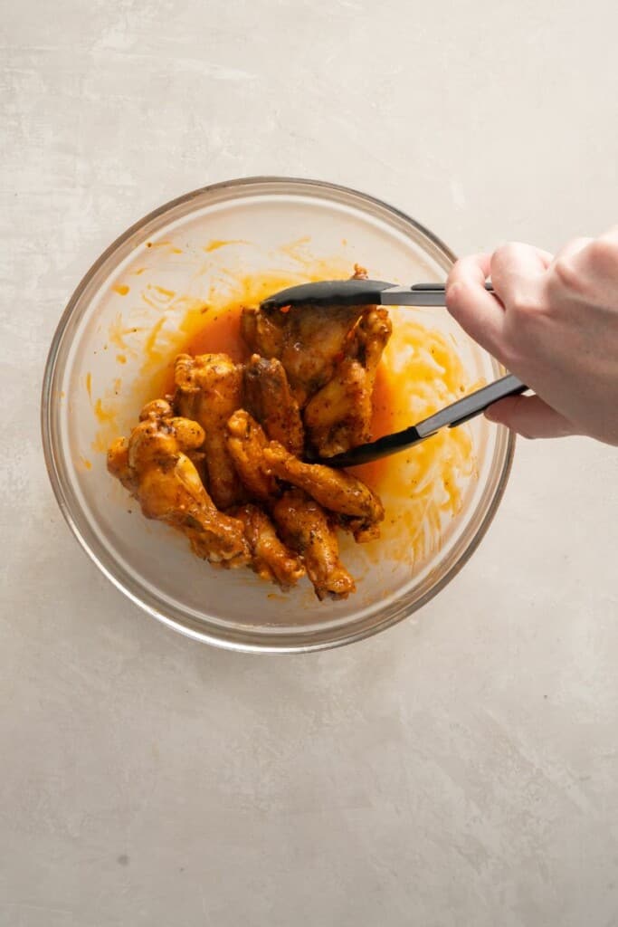 dipping wings into buffalo sauce