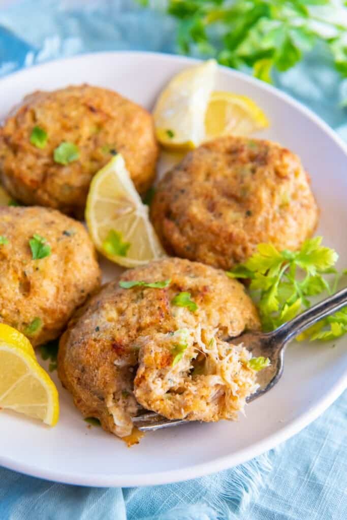 crab cakes with a fork scooping a bite