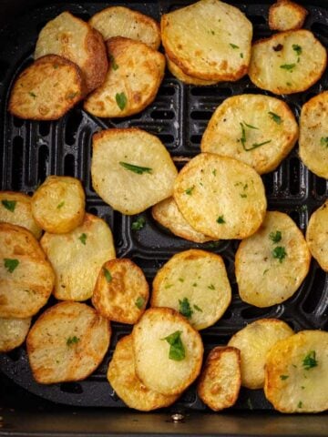 Air fryer sliced potatoes in air fryer basket