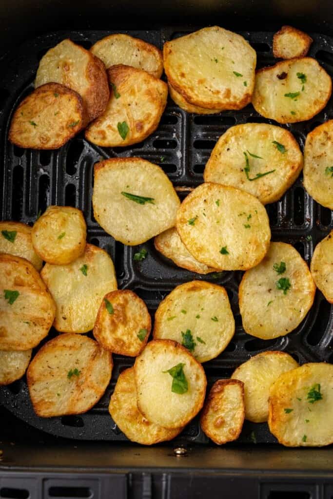 Air fryer sliced potatoes in air fryer basket