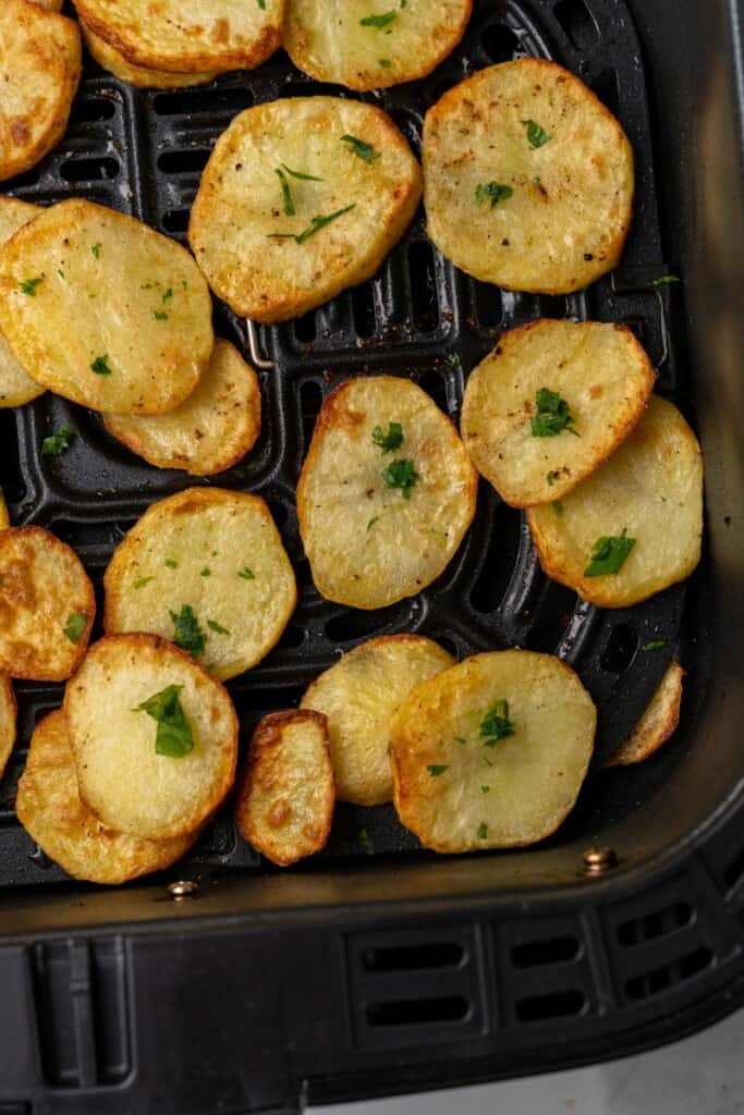 sliced potatoes in air fryer basket