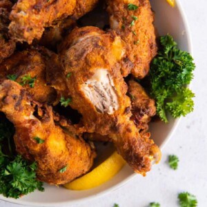 air fried chicken on plate with a bite taken out of a drumstick