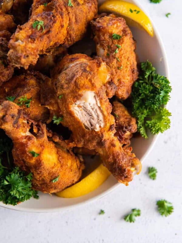 air fried chicken on plate with a bite taken out of a drumstick