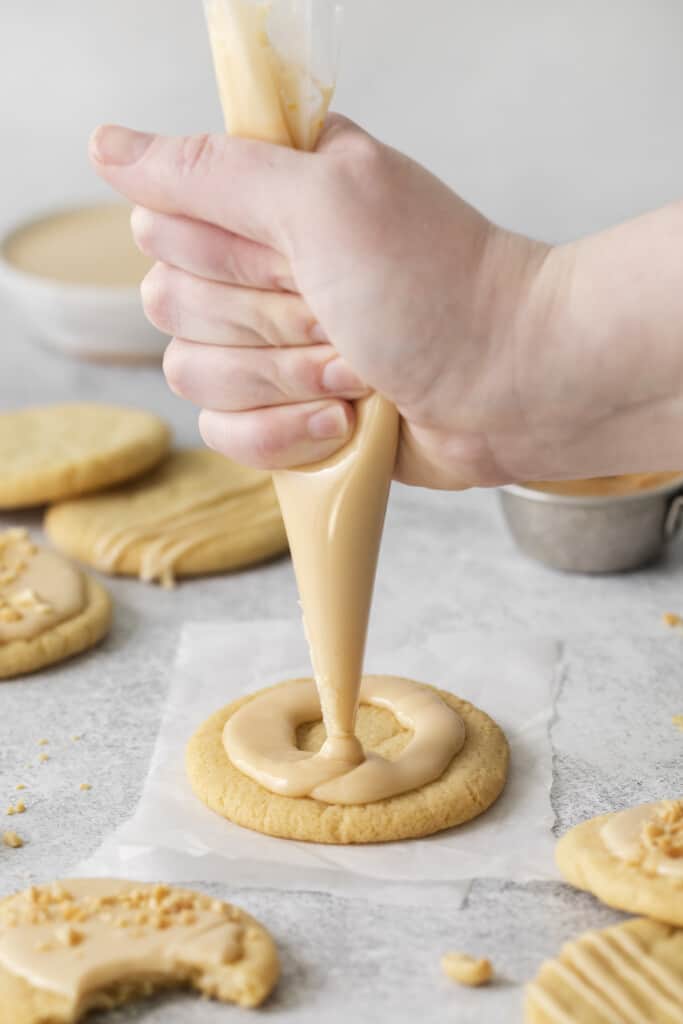 adding peanut butter icing to a cookie