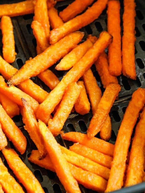 Sweet potato fries in an air fryer basket cooked.