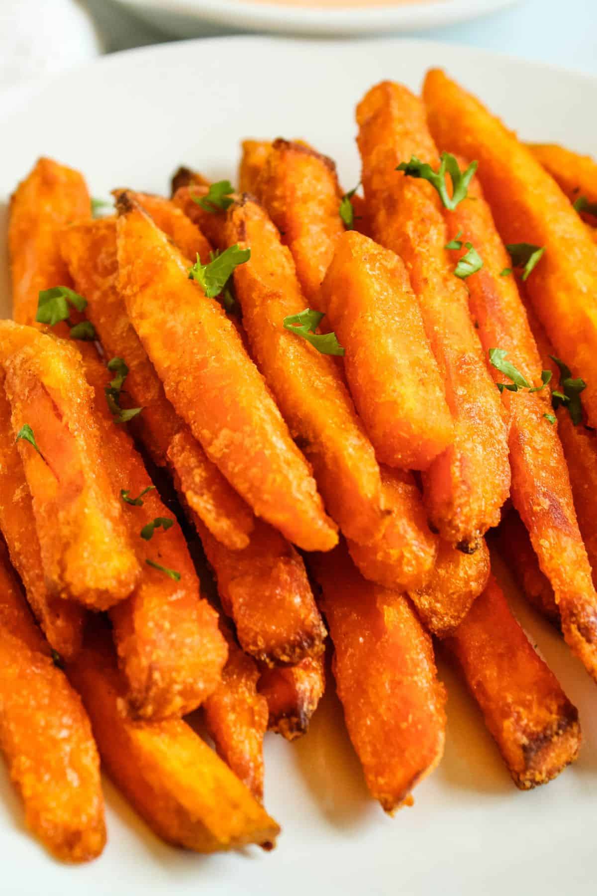 Air fryer frozen sweet potato fries on a white plate.