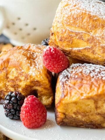 several pieces of hawaiian french toast rolls on a plate with fresh berries