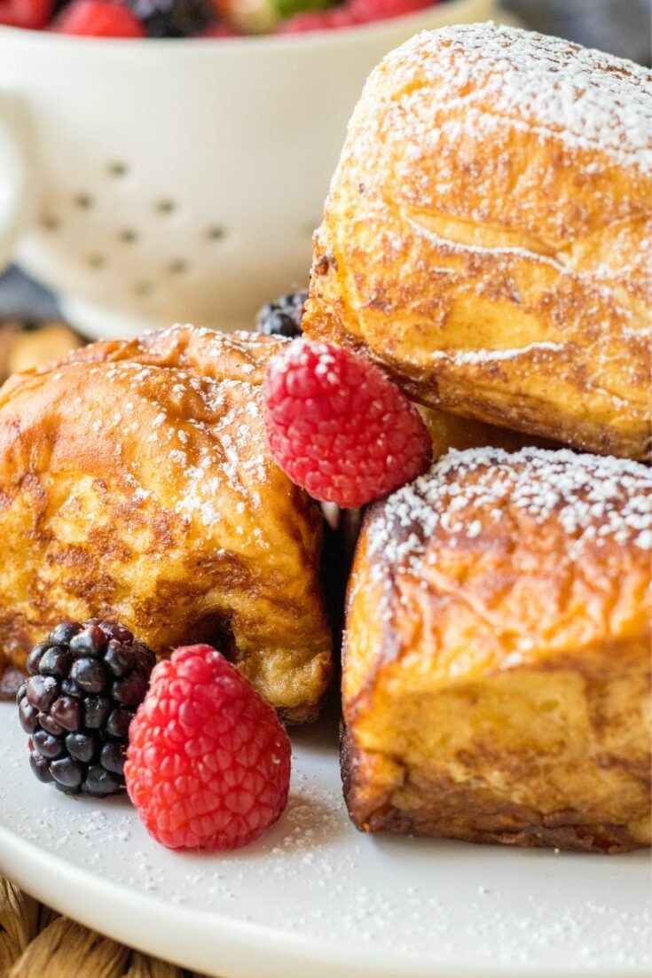several pieces of hawaiian french toast rolls on a plate with fresh berries