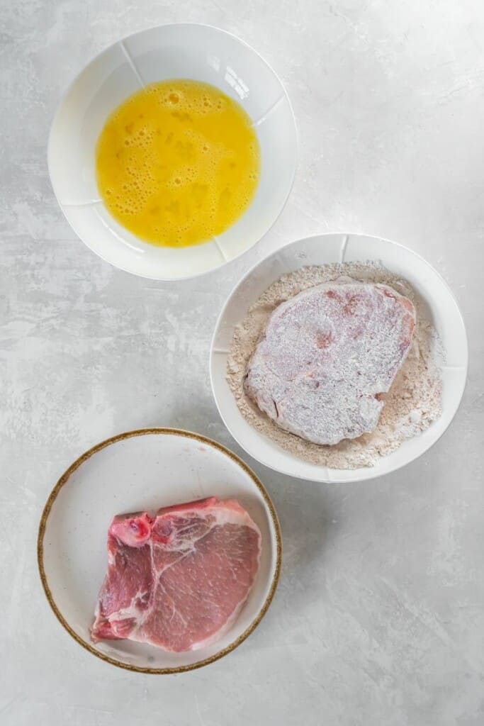 adding flour to pork chop