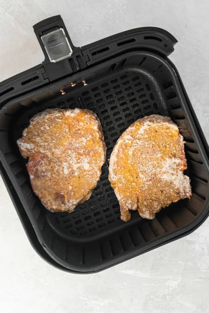 floured pork chops in air fryer basket