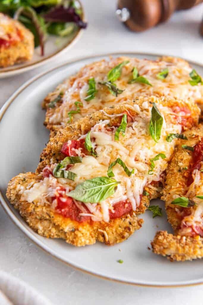 Closeup of air fryer chicken parm on a white plate.