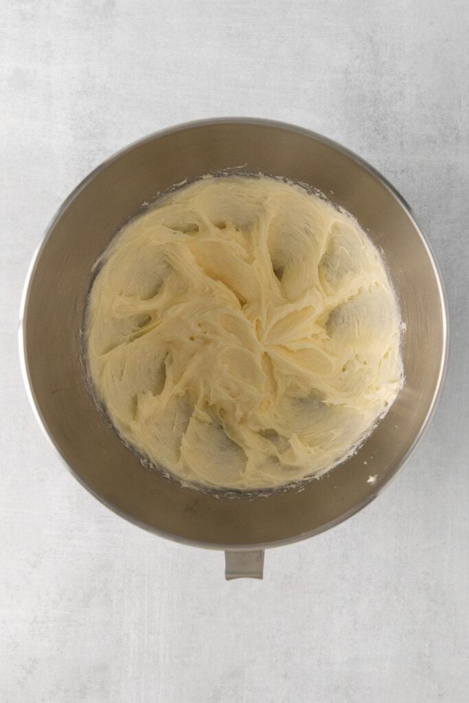 Butter, cream cheese, and sugar creamed in a mixing bowl to make cookies and cream cheesecake cookies.