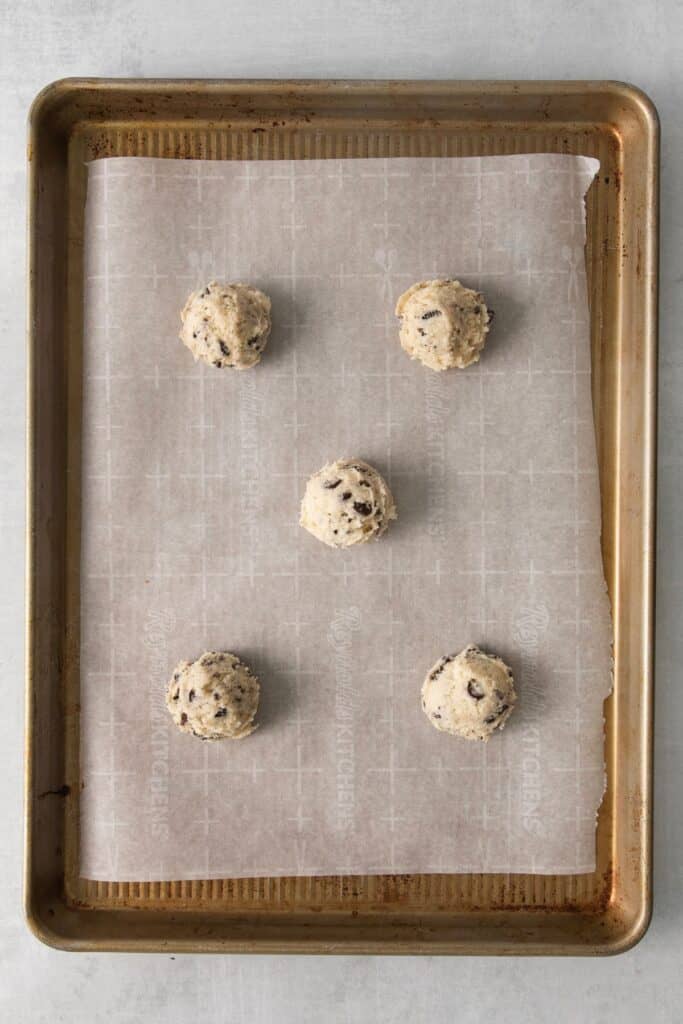 Oreo cookie recipe dough balls on a cookie sheet with parchment paper ready to be baked.