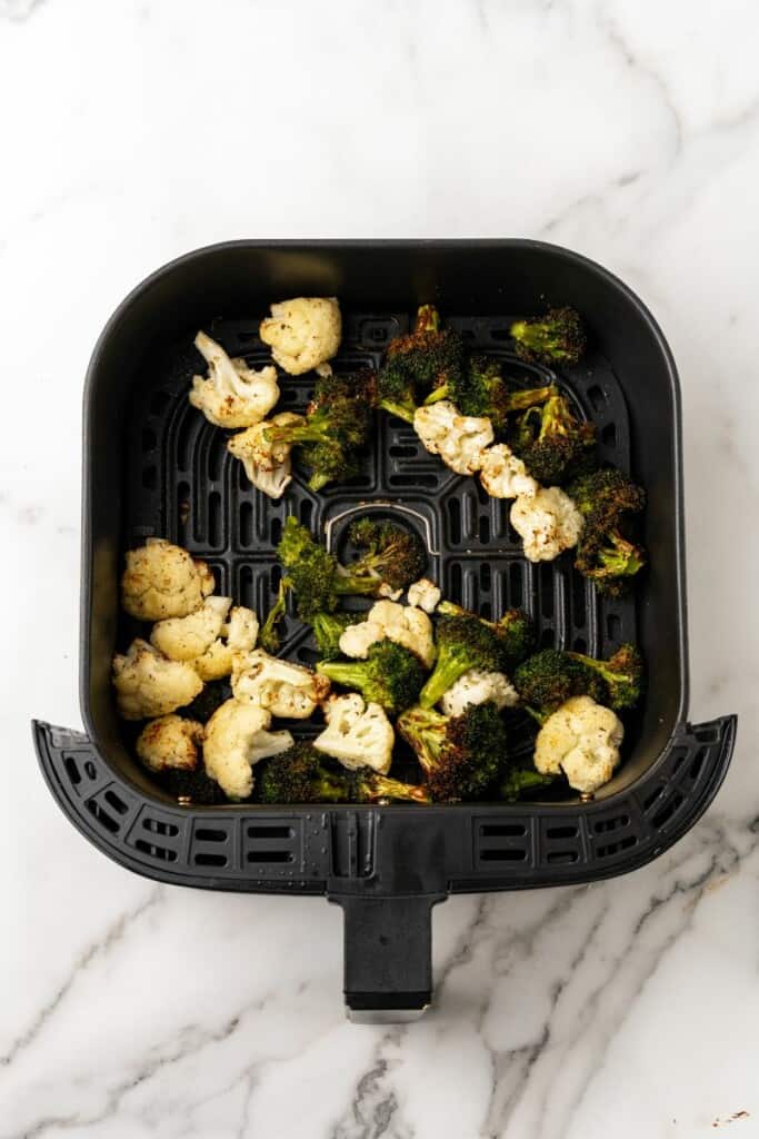 Air Fried Broccoli and Cauliflower in a black air fryer basket.