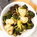 Broccoli and Cauliflower prepared in the air fryer, served in a white bowl.