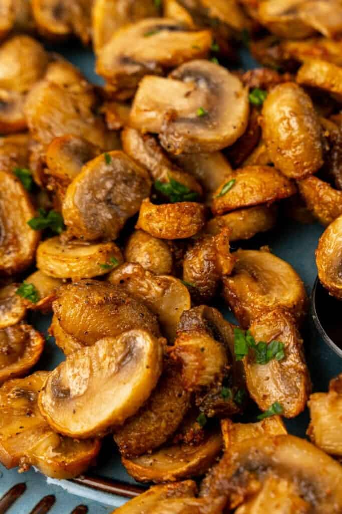 Closeup view of air fried mushrooms sprinkled with parsley.