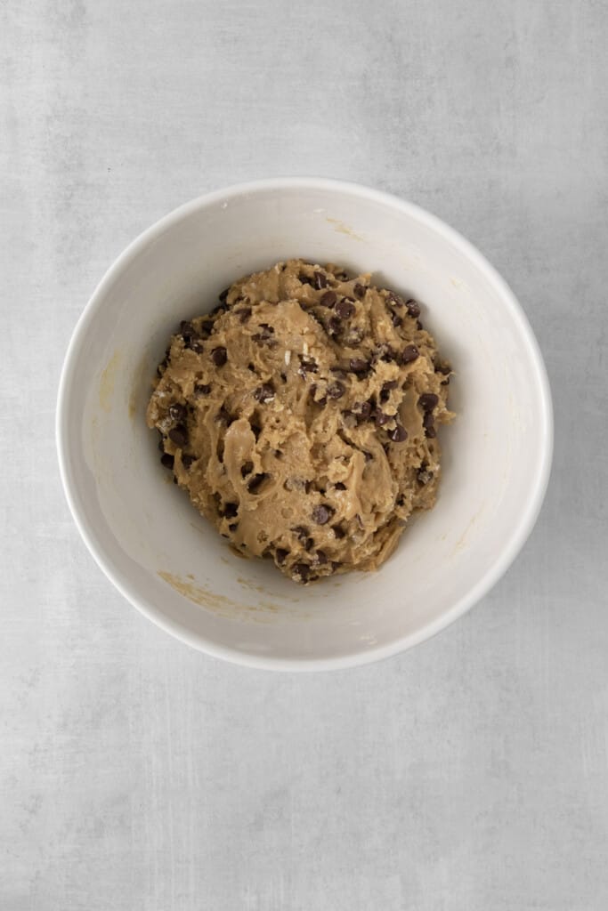 Overhead view of of baking soda, salt, flour, and chocolate chips after they are mixed.