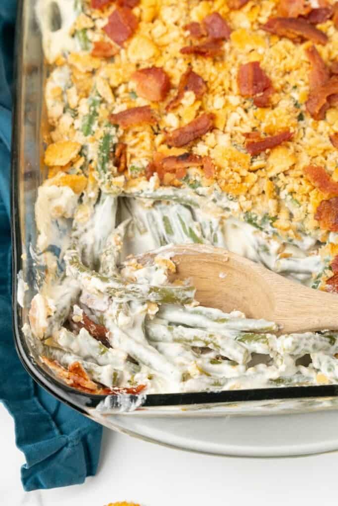 Green Bean Casserole in a clear 9x13 baking dish with a scoop removed.