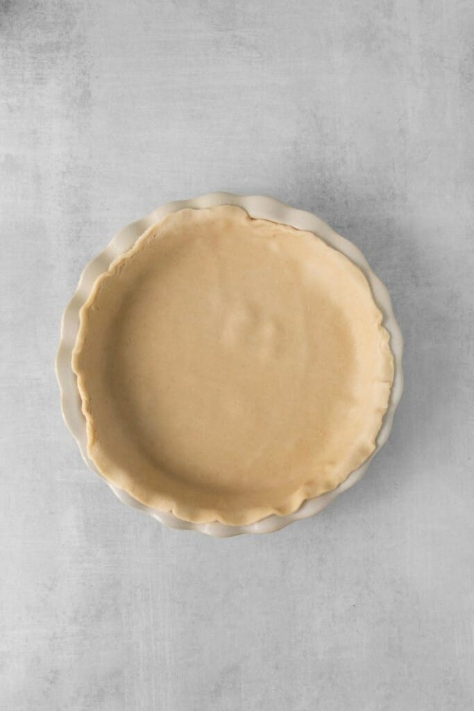 Overhead view of unbaked pie crust in a pie pan.
