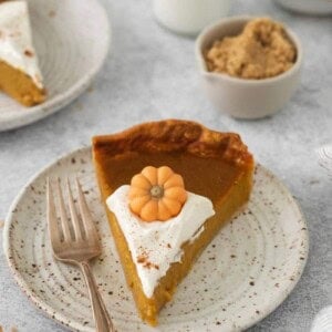 A slice of pumpkin pie prepared without evaporated milk on a white plate with a fork.
