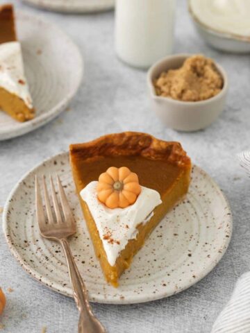 A slice of pumpkin pie prepared without evaporated milk on a white plate with a fork.