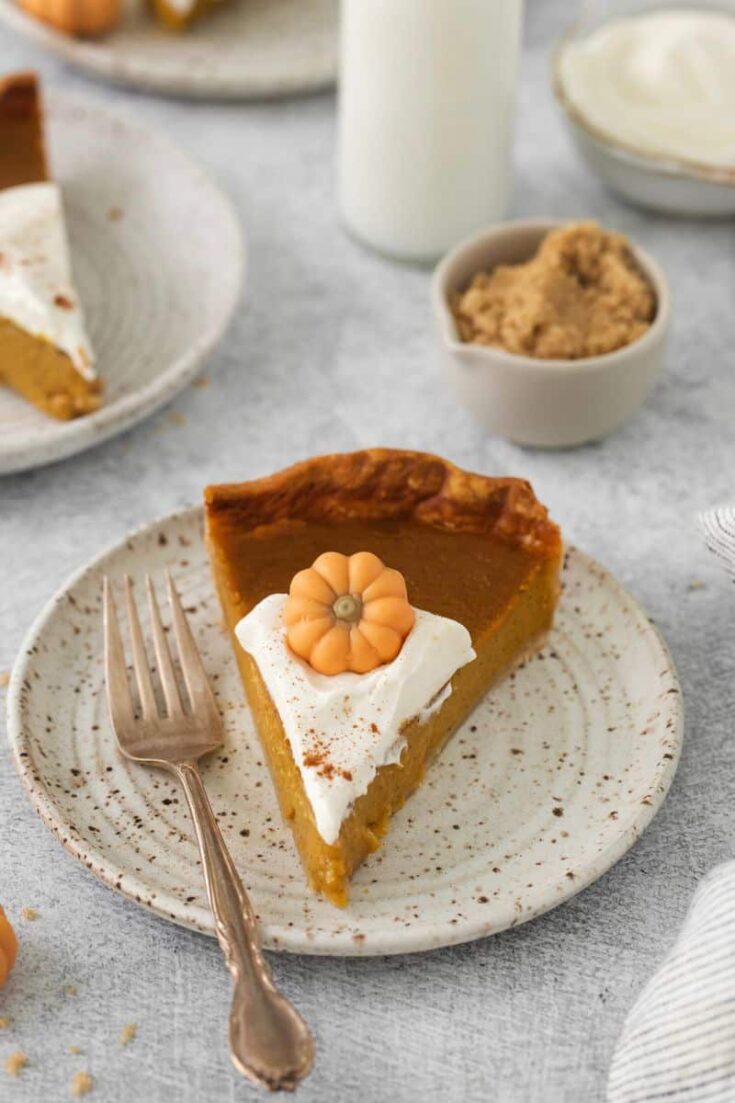 A slice of pumpkin pie prepared without evaporated milk on a white plate with a fork.