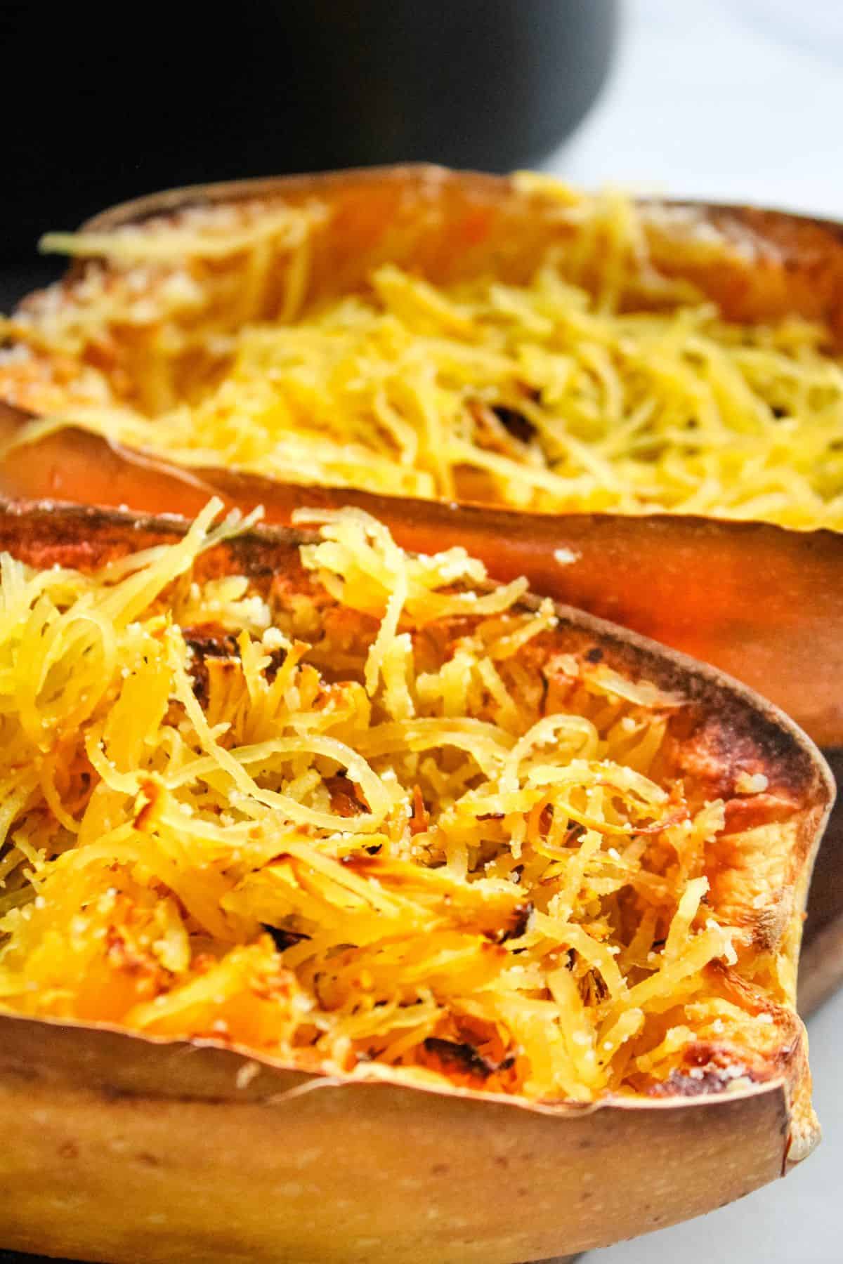 Close up of the air fryer spaghetti squash still in the half, but the strands pulled into pieces.