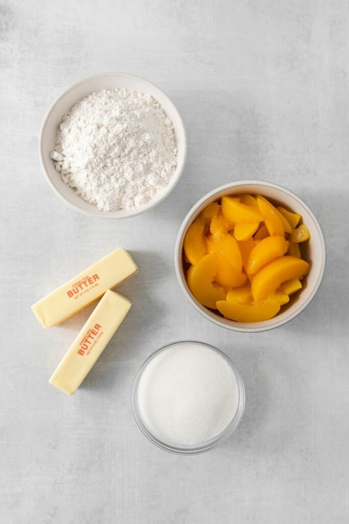 Overhead view of the four ingredients needed to make this peach cobbler.